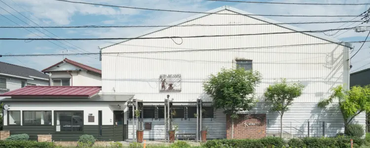 白い外壁と赤い屋根が特徴の工房外観
